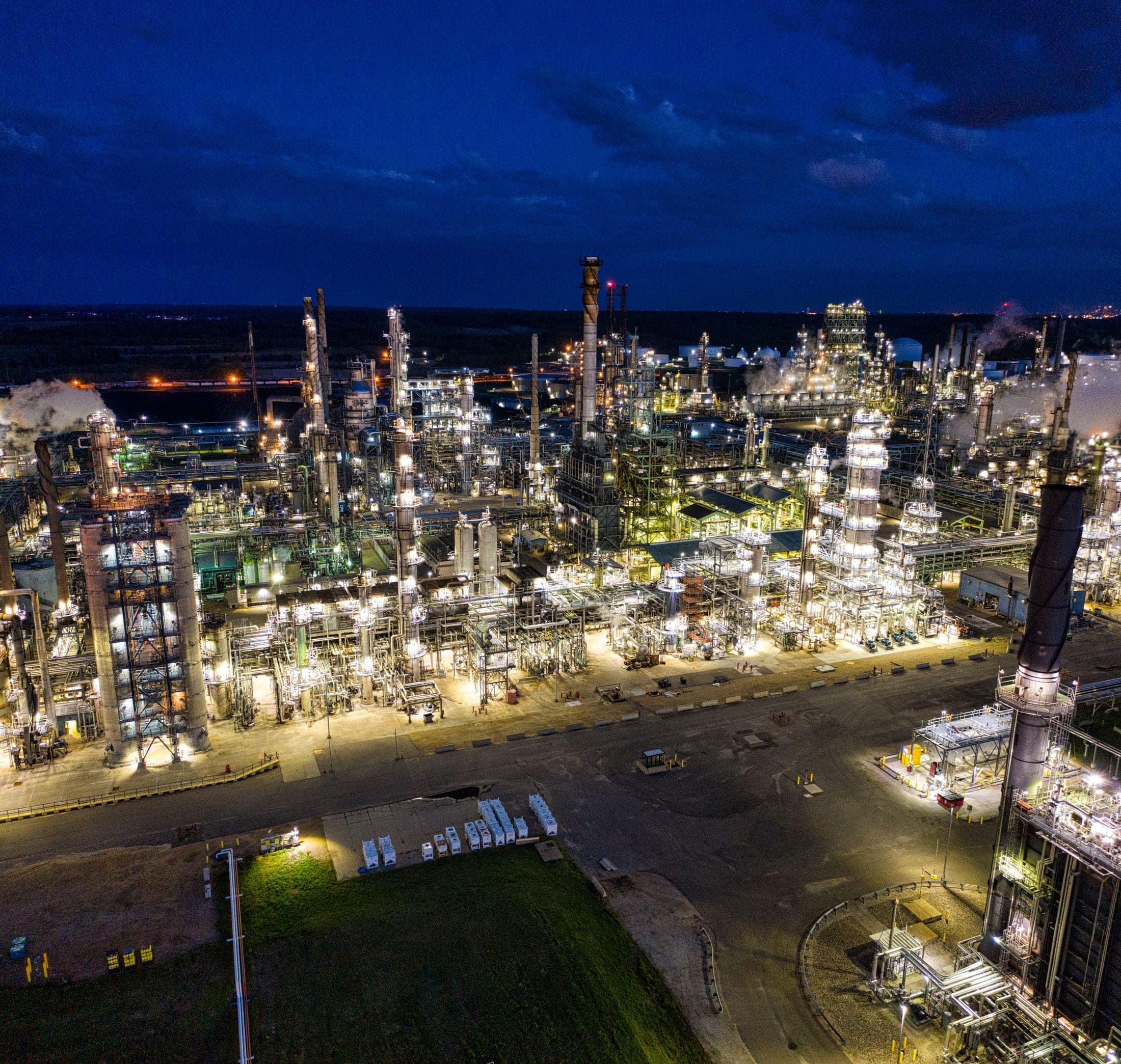 Illuminated refinery complex photographed from the air at night