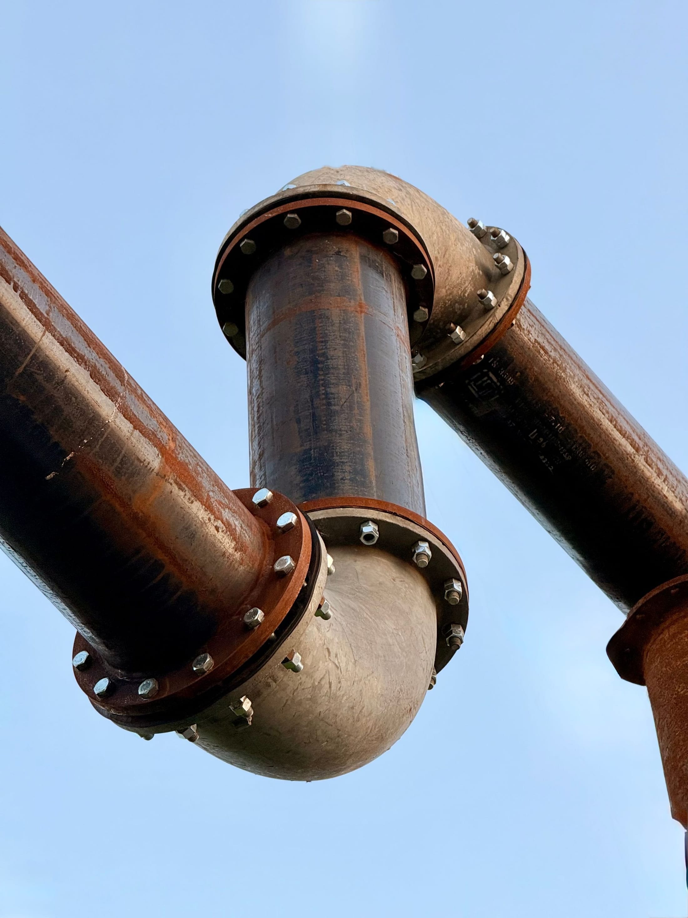 Large flanged pipe sections bolted together against an open sky