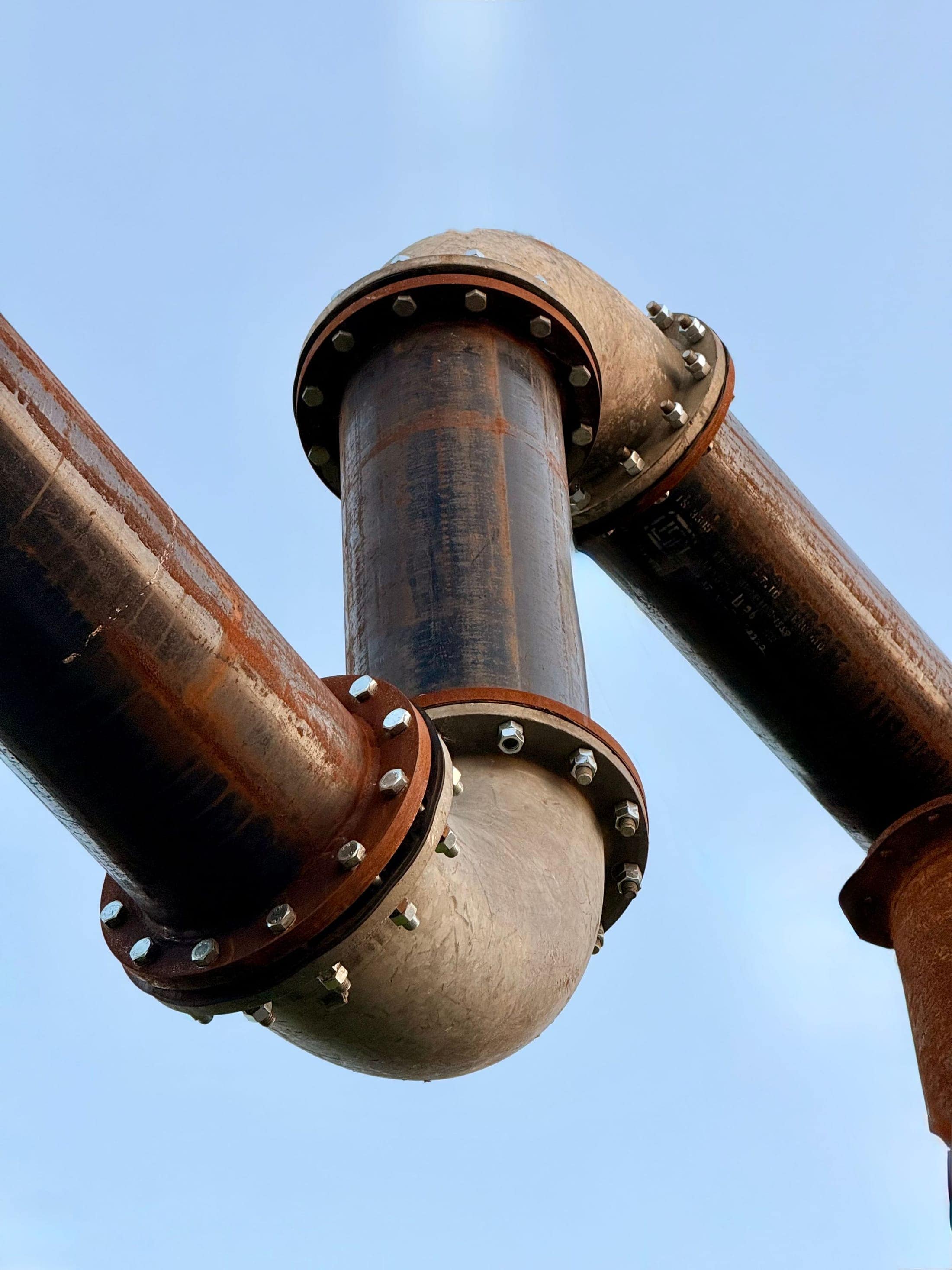 Large flanged pipe sections bolted together against an open sky