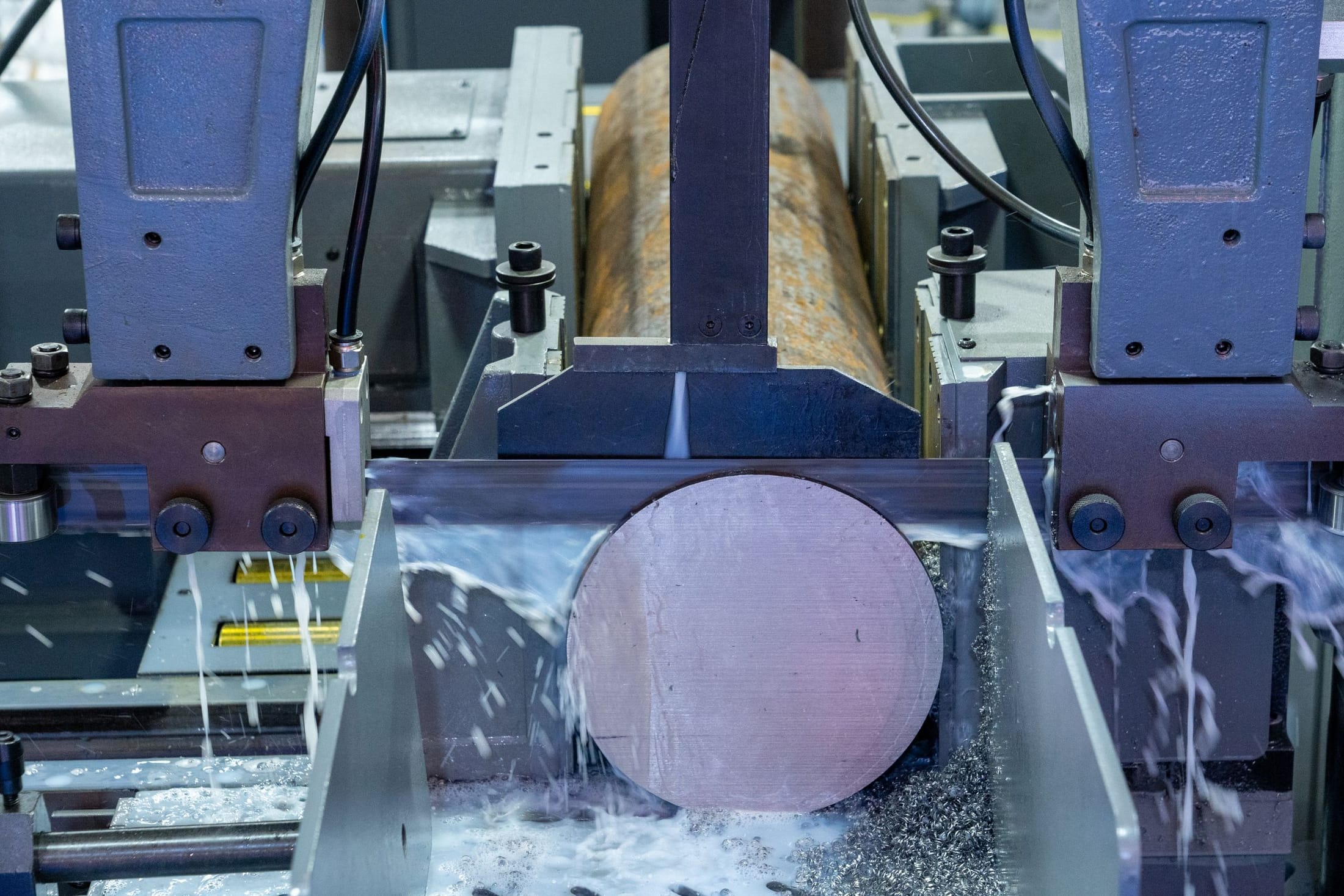 Machine tool cutting a cylindrical workpiece under coolant